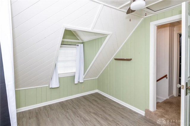 bonus room featuring hardwood / wood-style flooring and wooden walls