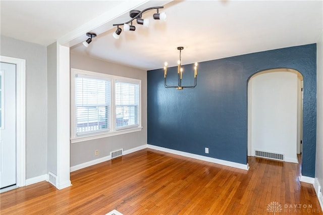 unfurnished dining area with hardwood / wood-style floors and a chandelier