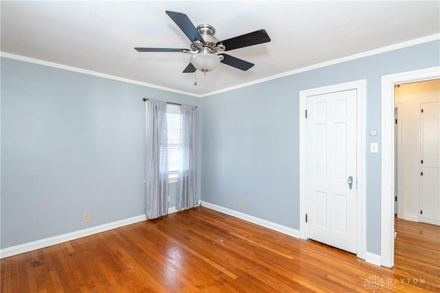 spare room featuring wood-type flooring, ceiling fan, and ornamental molding