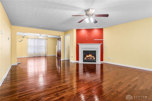 unfurnished living room with ceiling fan, hardwood / wood-style floors, and a textured ceiling