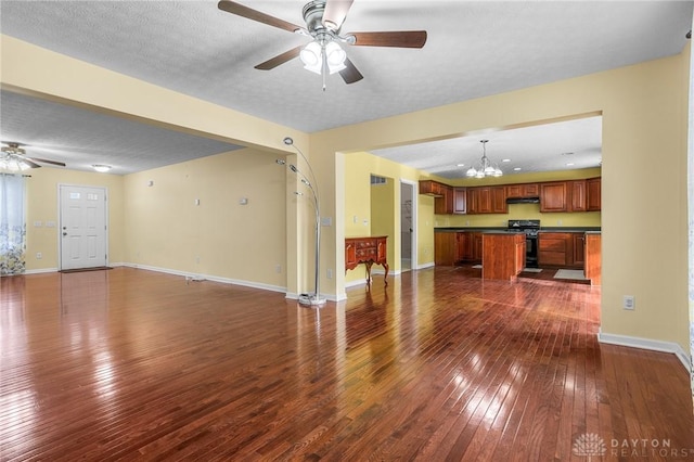 unfurnished living room with ceiling fan with notable chandelier, a textured ceiling, and dark hardwood / wood-style flooring