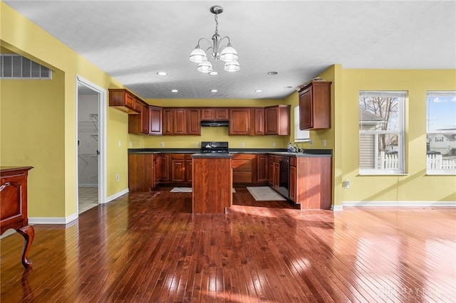 kitchen featuring dark wood-type flooring, black stove, a notable chandelier, a kitchen island, and dishwashing machine