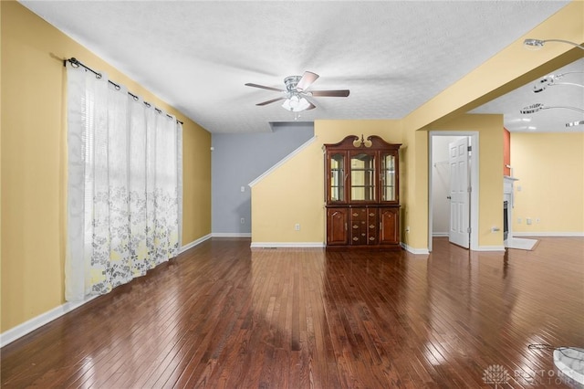 spare room with dark hardwood / wood-style floors, ceiling fan, and a textured ceiling