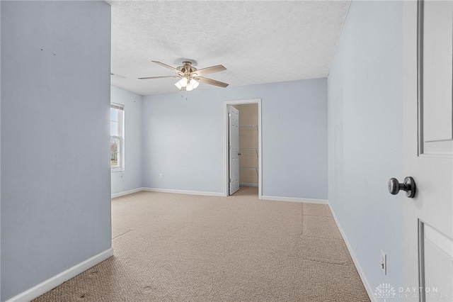 carpeted spare room featuring ceiling fan and a textured ceiling