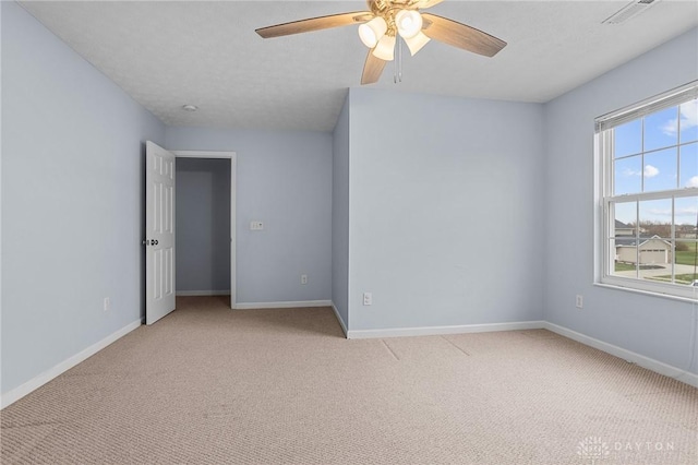 spare room featuring ceiling fan and light colored carpet