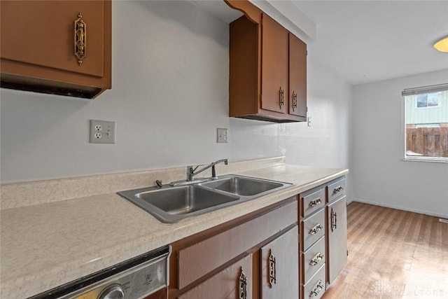 kitchen featuring sink, stainless steel dishwasher, and light wood-type flooring