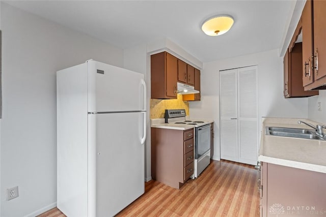 kitchen featuring stainless steel range with electric cooktop, sink, light hardwood / wood-style flooring, tasteful backsplash, and white fridge