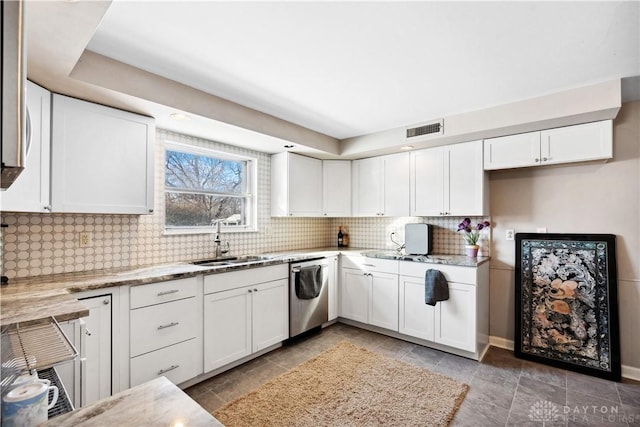 kitchen with light stone countertops, sink, white cabinets, and stainless steel dishwasher