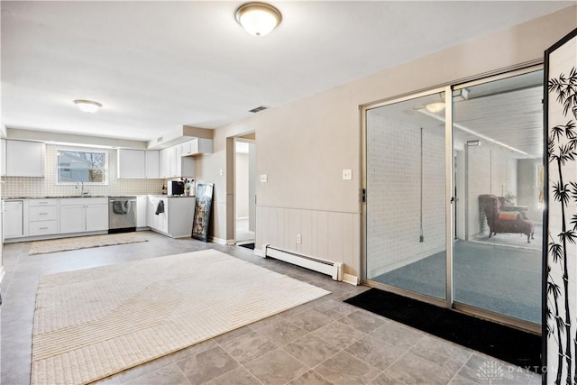 kitchen featuring dishwasher, white cabinets, sink, decorative backsplash, and a baseboard radiator