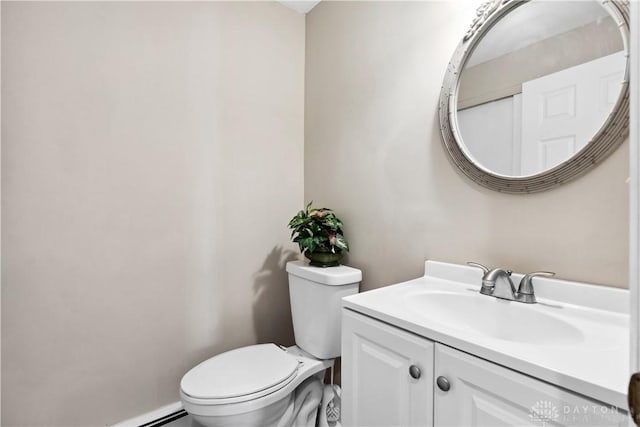 bathroom with vanity, toilet, and a baseboard heating unit