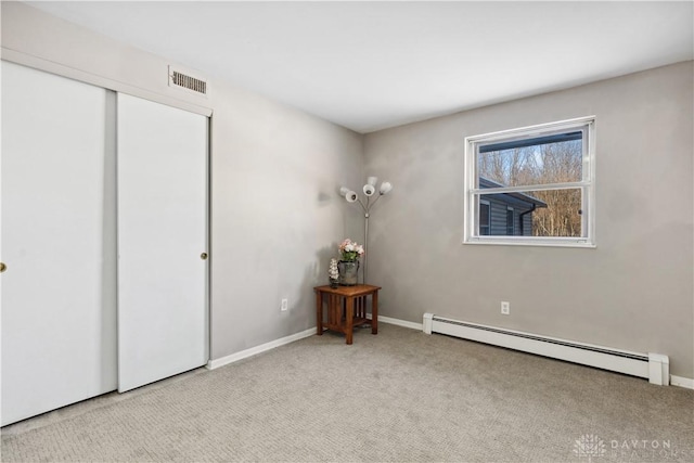 unfurnished bedroom with light carpet, a closet, and a baseboard radiator