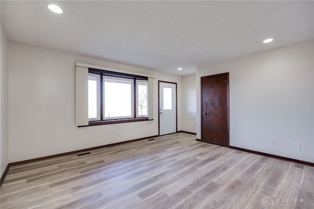 unfurnished room featuring a textured ceiling and light hardwood / wood-style floors