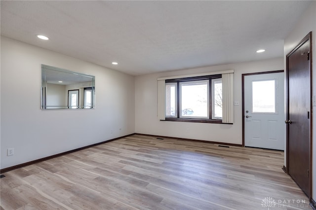 interior space featuring light wood-type flooring and a textured ceiling