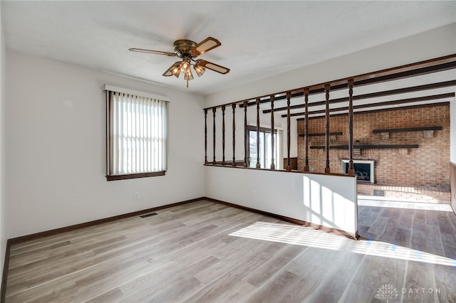 spare room featuring ceiling fan, light hardwood / wood-style floors, and a textured ceiling