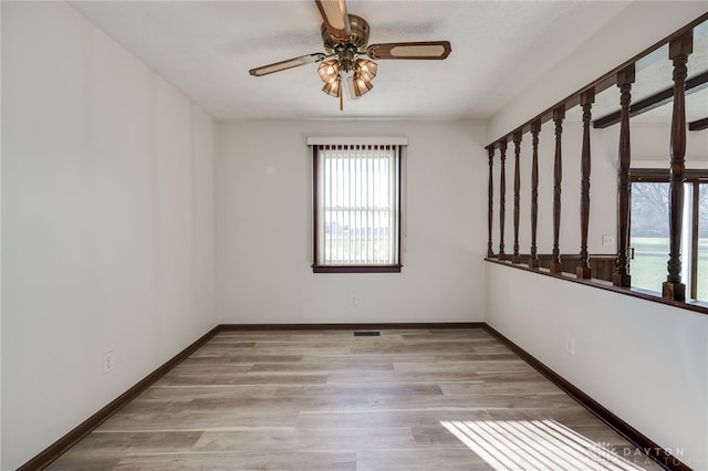 empty room featuring ceiling fan, light wood-type flooring, and a textured ceiling