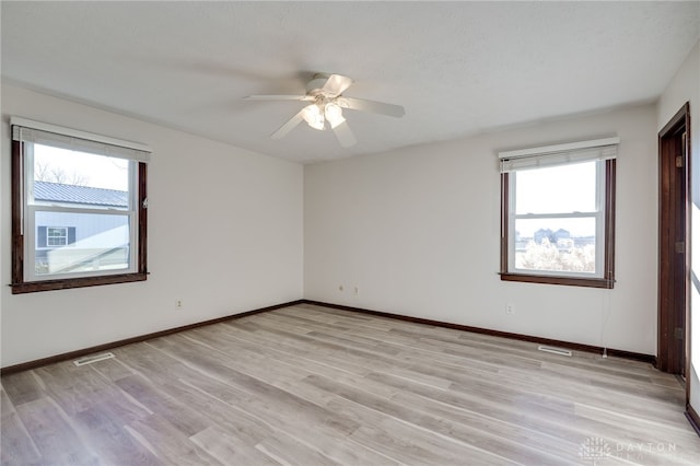 spare room featuring a textured ceiling, light hardwood / wood-style floors, a wealth of natural light, and ceiling fan