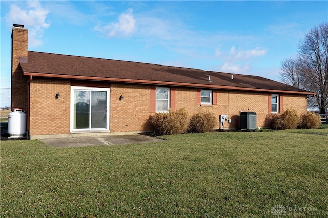 rear view of house with a yard, a patio, and central air condition unit