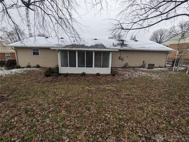 rear view of property with a sunroom and central AC