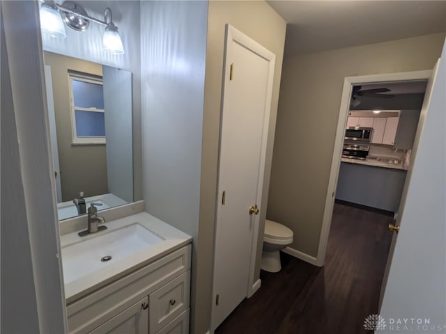 bathroom with wood-type flooring, vanity, and toilet