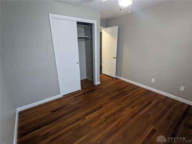 unfurnished bedroom featuring ceiling fan, a closet, and dark hardwood / wood-style floors