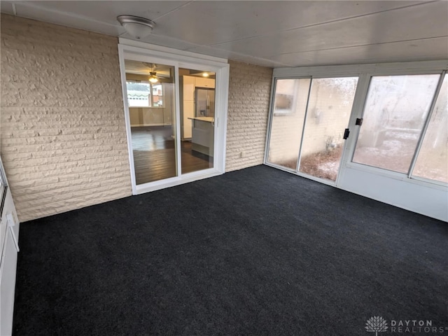 unfurnished sunroom featuring ceiling fan