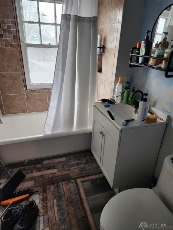 full bathroom with toilet, vanity, and shower / tub combo with curtain