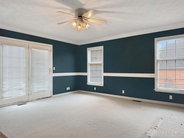 carpeted empty room with ceiling fan and ornamental molding