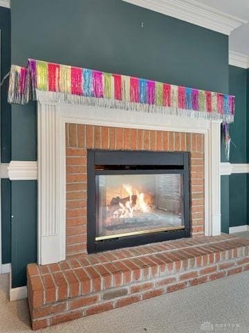 interior details featuring a fireplace, carpet floors, and crown molding