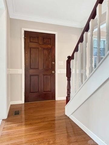 entrance foyer with light hardwood / wood-style floors and ornamental molding