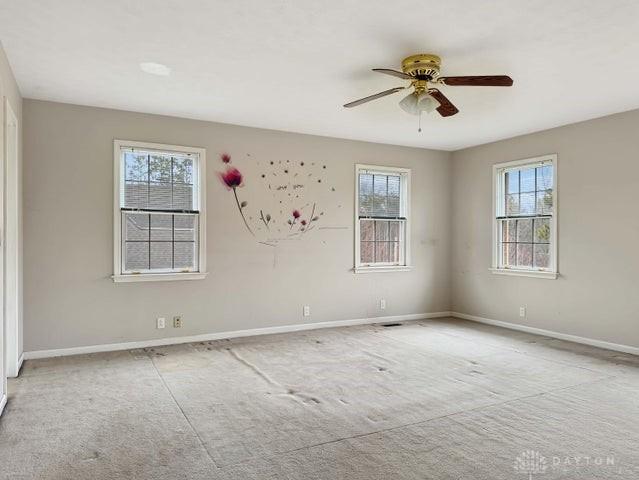 unfurnished room featuring light colored carpet and ceiling fan