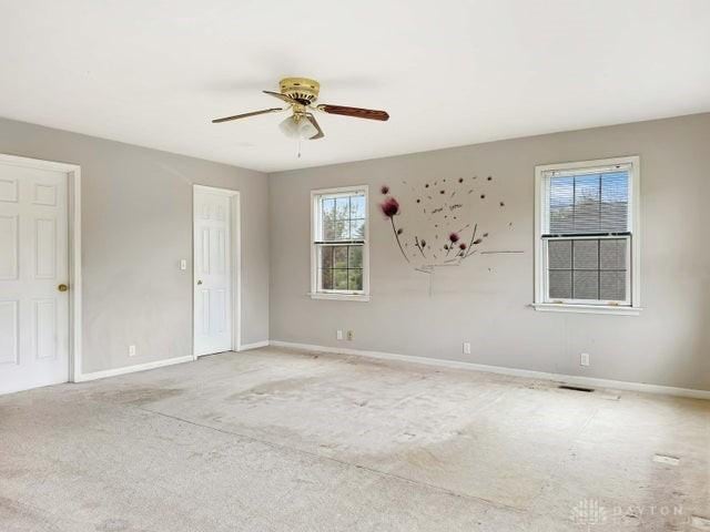 carpeted spare room featuring ceiling fan