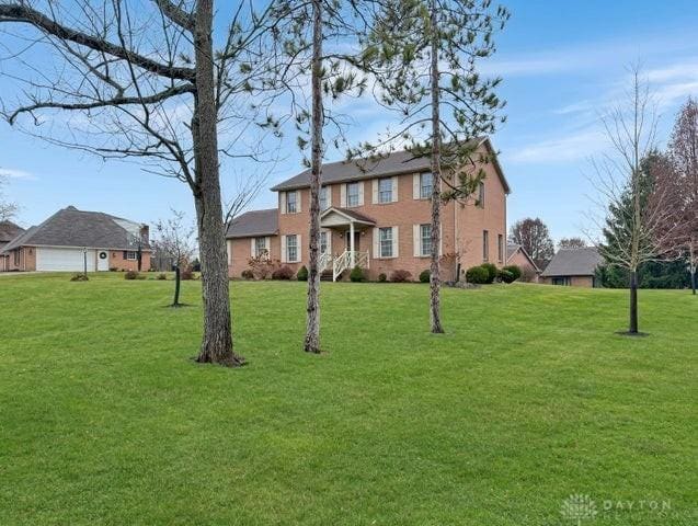 colonial inspired home with a front lawn