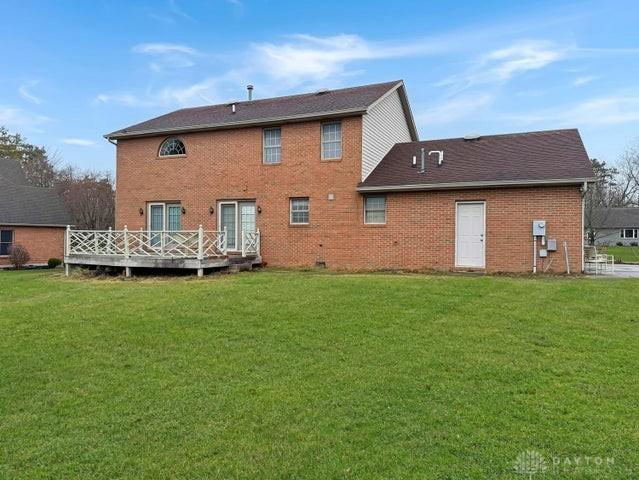 back of property featuring a yard and a deck