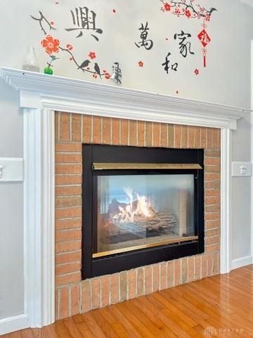 interior details featuring hardwood / wood-style floors and a brick fireplace