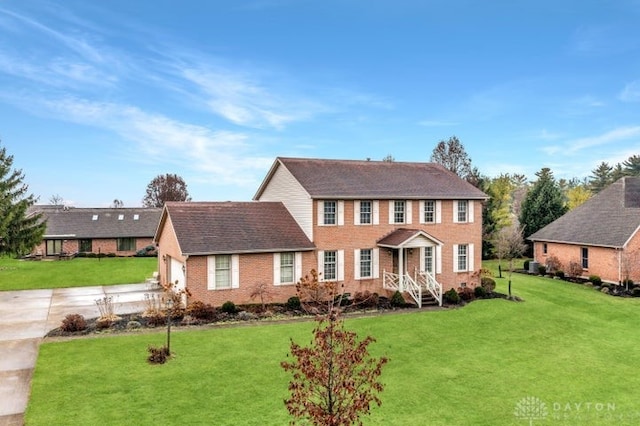 colonial inspired home with a front lawn and a garage