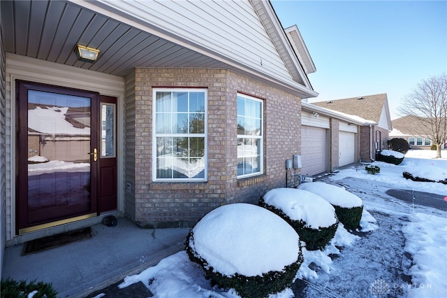 view of snow covered exterior featuring a garage