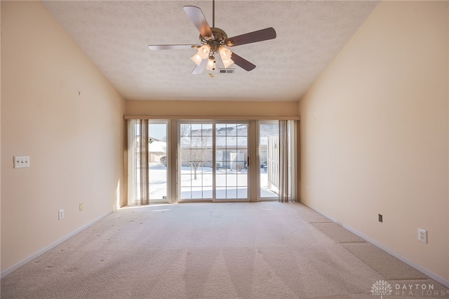 unfurnished room featuring light colored carpet, ceiling fan, and a textured ceiling