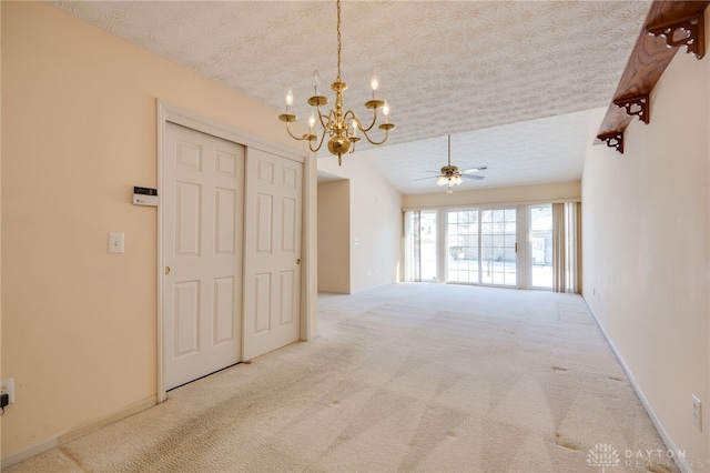 spare room featuring a textured ceiling, light colored carpet, lofted ceiling, and ceiling fan with notable chandelier