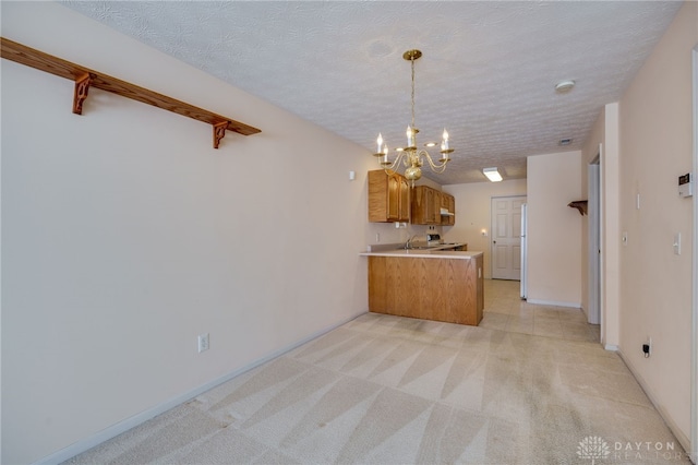 kitchen featuring white fridge, light carpet, kitchen peninsula, a notable chandelier, and a textured ceiling