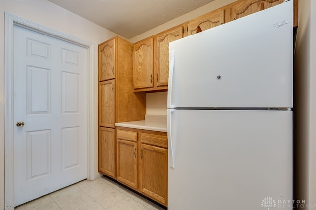 kitchen with white fridge and light tile patterned floors