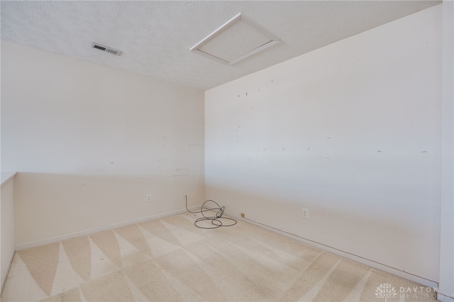 carpeted empty room featuring a textured ceiling