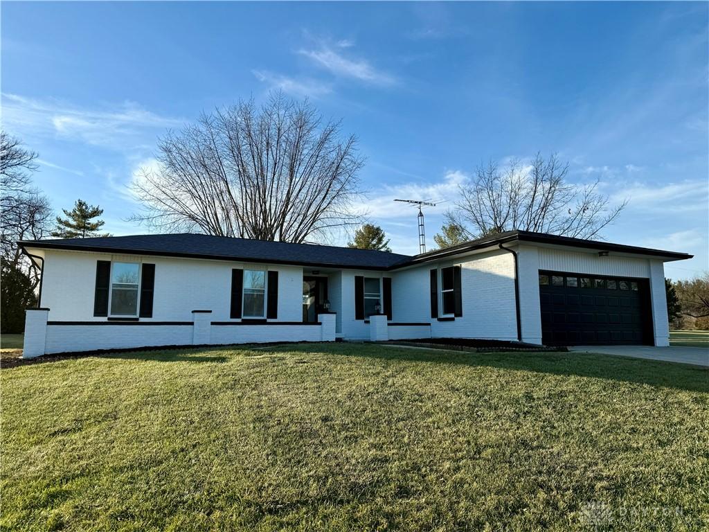 single story home featuring a front yard and a garage