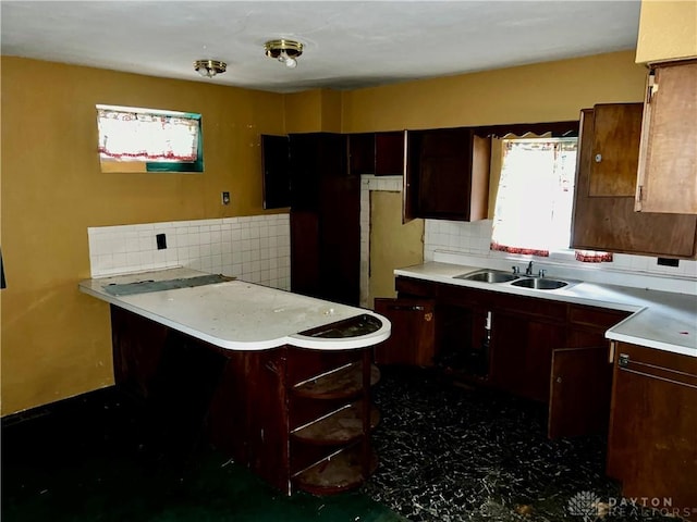 kitchen featuring kitchen peninsula, sink, and tasteful backsplash