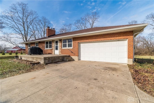 ranch-style home featuring brick siding, driveway, a chimney, and an attached garage