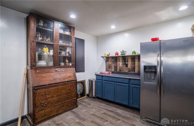 kitchen with blue cabinetry, stainless steel fridge with ice dispenser, and hardwood / wood-style floors