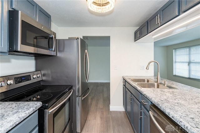 kitchen with hardwood / wood-style floors, appliances with stainless steel finishes, and sink