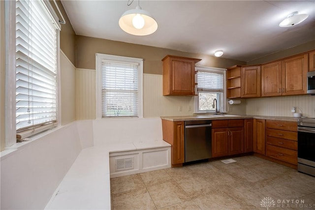 kitchen featuring a healthy amount of sunlight, sink, hanging light fixtures, and appliances with stainless steel finishes