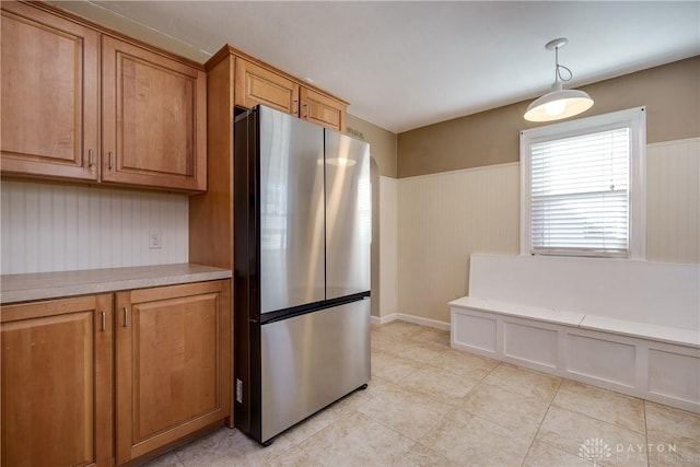 kitchen featuring light tile patterned floors, decorative light fixtures, and stainless steel refrigerator