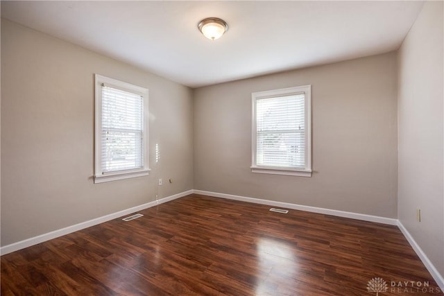 unfurnished room with dark hardwood / wood-style flooring