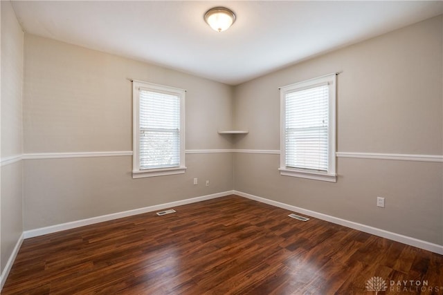 unfurnished room featuring dark hardwood / wood-style floors and plenty of natural light